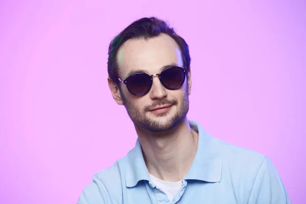 Estudio de tiro de hombre guapo con gafas de sol sobre fondo rosa . — Foto de Stock