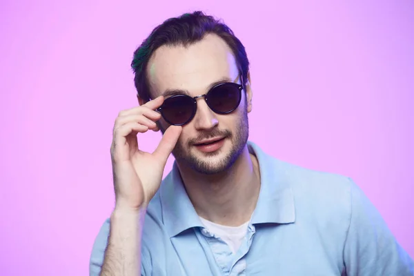 Estudio de tiro de hombre guapo con gafas de sol sobre fondo rosa . — Foto de Stock