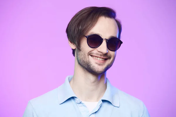 Estudio de tiro de hombre guapo con gafas de sol sobre fondo rosa . — Foto de Stock