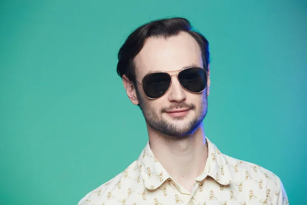 Estudio de tiro de hombre guapo con gafas de sol sobre fondo verde . — Foto de Stock