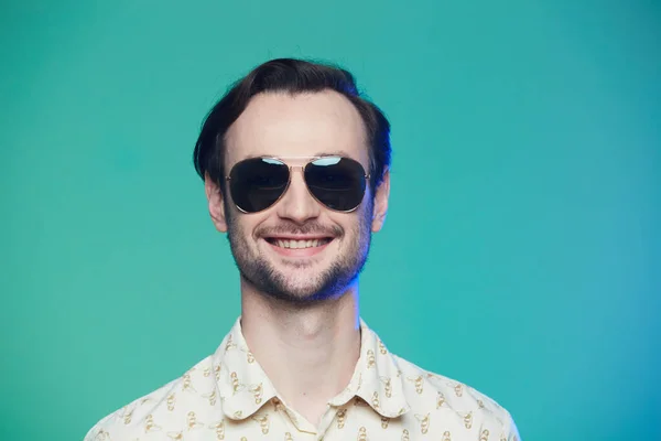 Estudio de tiro de hombre guapo con gafas de sol sobre fondo verde . — Foto de Stock