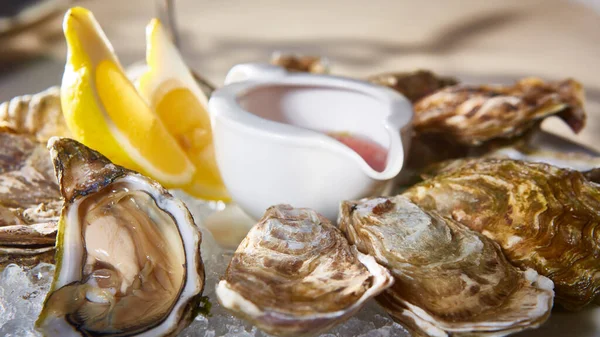 Fresh oysters on ice with lemon close up. Shallow dof. — Stock Photo, Image