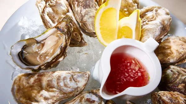 Geopende verse oesters met citroen op schotel. Ondiepe dof — Stockfoto