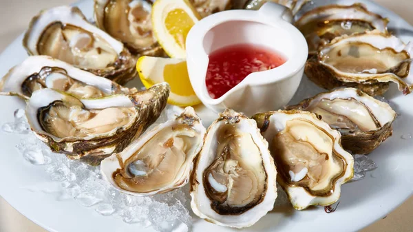 Geopende verse oesters met citroen op schotel. Ondiepe dof — Stockfoto