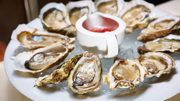 Opened fresh oysters with lemon on dish. Shallow dof — Stock Photo, Image