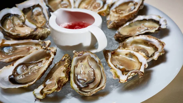 Fresh oysters on ice with lemon close up. Shallow dof. — Stock Photo, Image