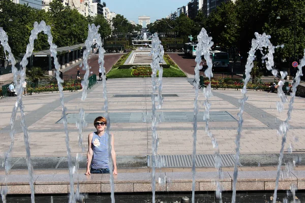 La giovane donna in fuga ondata di calore nella fontana della città — Foto Stock