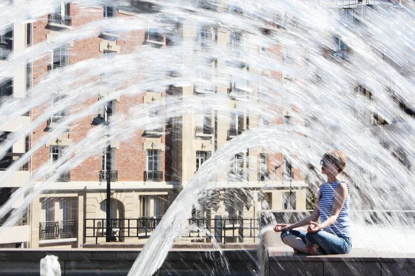 La giovane donna in fuga ondata di calore nella fontana della città — Foto Stock