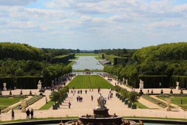 Versailles, Fransa - 26 Ağustos 2019: Parterre dEau 'dan Versailles bahçelerinin güzel manzarası. Ziyaretçiler Latona Çeşmesi 'nden Büyük Kanal' a kadar manzaranın tadını çıkarıyorlar..