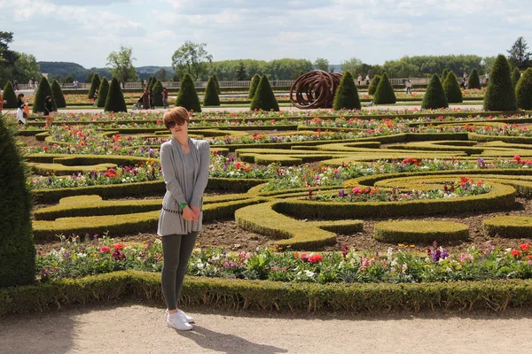 Young woman posing near the Parterre du Midi garden in the Palace of Versaille — Stock Photo, Image