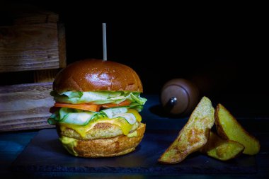 Siyah taşın üstünde patatesli kırsal balık burgeri