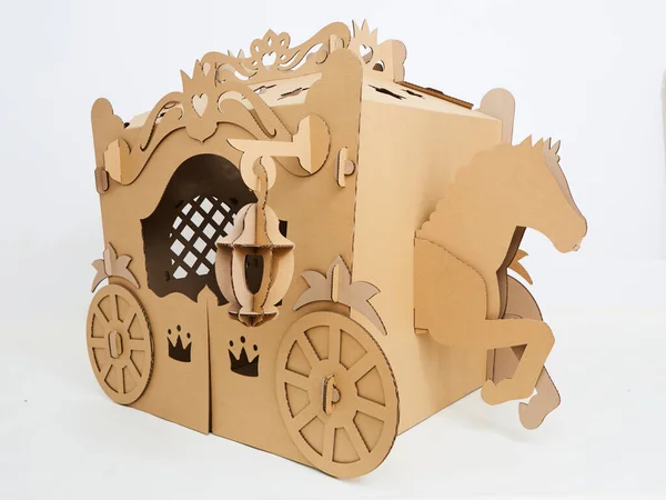 Um cavalo e uma carruagem feita de papelão marrom, onde o cavalo está puxando a carruagem . — Fotografia de Stock