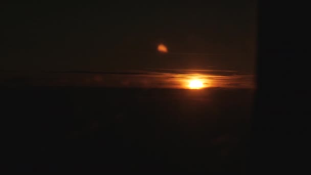 Vue aérienne large montrant le soleil en évidence à l'horizon se cachant derrière la fenêtre de l'avion 