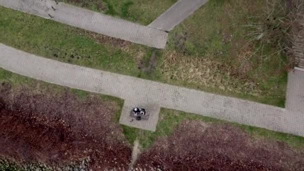 Duas Pessoas Sentadas Banco Lado Rio Parque Subindo Cima Aérea — Vídeo de Stock