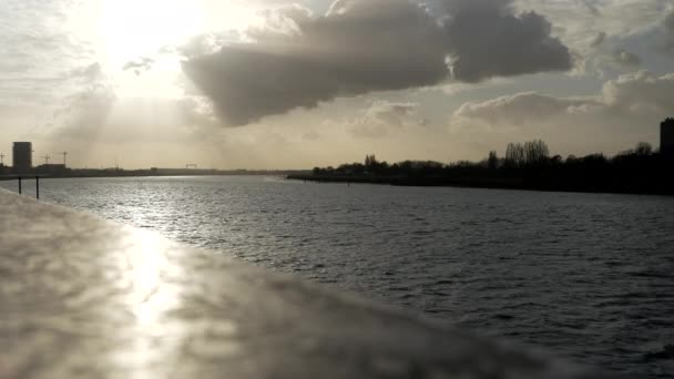 夕日の方向に川に観光船を渡すの静的なワイドショットシルエット — ストック動画