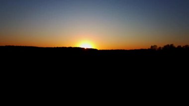 Ufuk siluetiyle arka planda güzel altın gün batımının destansı hava dronu