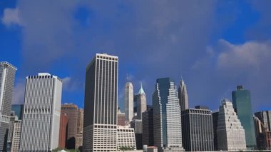 New York şehrinin ufuk çizgisinin ve mavi gökyüzünde akan bulutların zaman aşımına uğramış görüntüsü