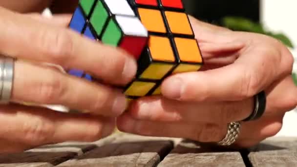 Zbliżenie Strzał Inteligentny Człowiek Ręce Rozwiązywanie Kostki Rubik Słoneczny Dzień — Wideo stockowe
