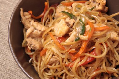 Kahverengi plaka zekâ kızarmış noodle tavuk ve sebze ile karıştırın