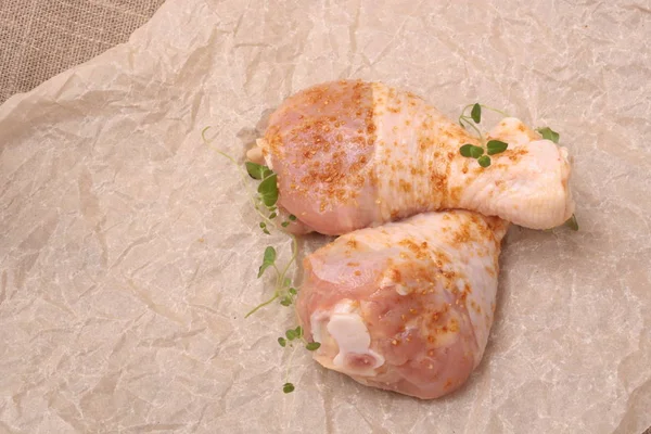 Patas de pollo crudo con especias en el fondo sobre papel — Foto de Stock