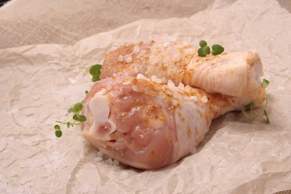 Raw chicken legs with spices on background on paper — Stock Photo, Image