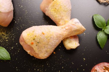 Tavuk uyluk bir siyah arka plan, domates ve fesleğen