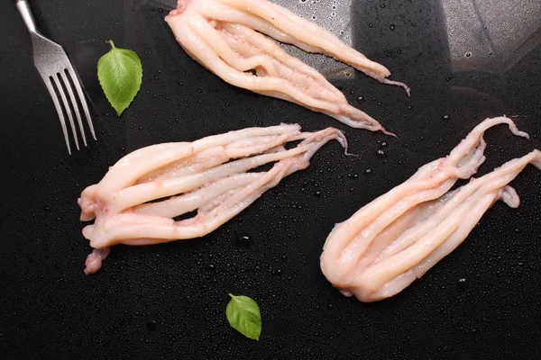 Tentakel Tintenfisch auf schwarzem Hintergrund, Tropfen, Gabel — Stockfoto