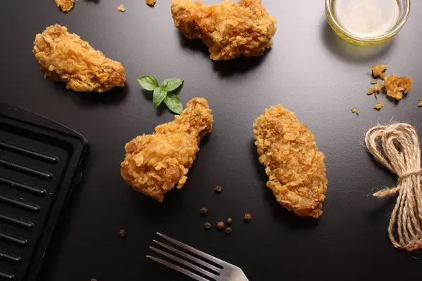 stock image Wings of chicken in breading on a black background, butter and b