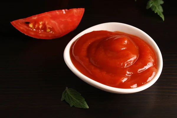 Кетчуп на чорному тлі і томатний базилік — стокове фото