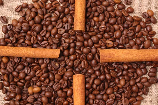 Coffee beans and cinnamon on a sacking background — Stock Photo, Image