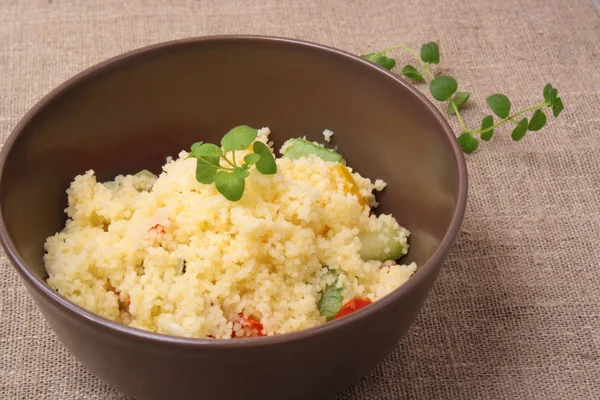 Kuskus ve kahverengi bir tabak içinde kavrulmuş sebze salatası — Stok fotoğraf