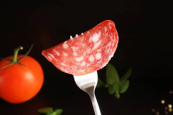 Salame Espanha salsicha Salchichon em um garfo em um backgr preto escuro — Fotografia de Stock