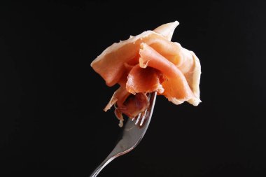 Prosciutto, jamon çatal karanlık bir arka plan üzerinde