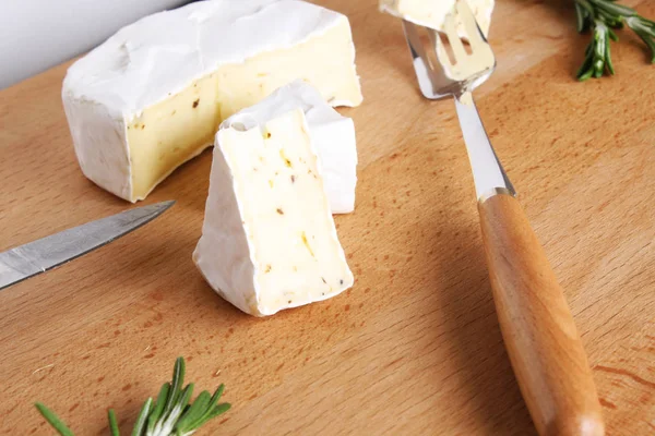 Queijo brie em um fundo de madeira — Fotografia de Stock