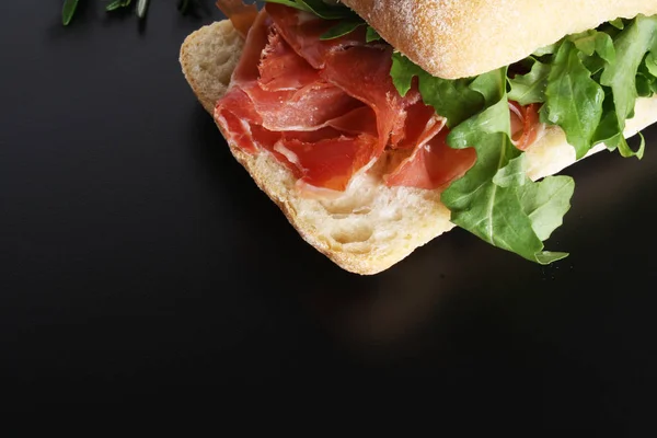 Sandwich prosciutto hamon ciabatta uno sfondo scuro — Foto Stock