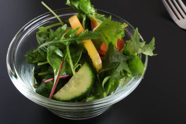 Siyah arka planda sebze salatası.