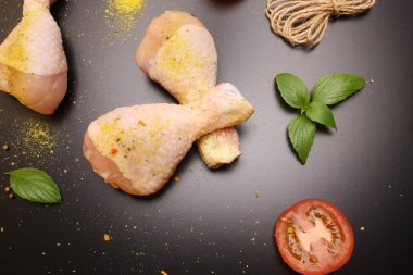 Tavuk uyluk bir siyah arka plan, domates ve fesleğen