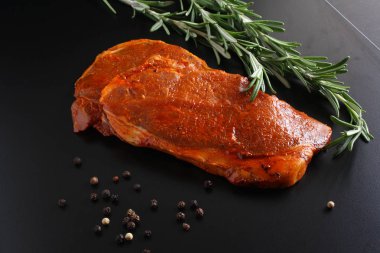 escalope domuz eti biftek, biberiye karanlık bir arka plan üzerinde