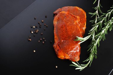 escalope domuz eti biftek, biberiye karanlık bir arka plan üzerinde