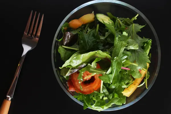 Plantaardige salade op een zwarte achtergrond — Stockfoto