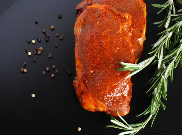 Escalope varkensvlees biefstuk, rozemarijn op een donkere achtergrond — Stockfoto
