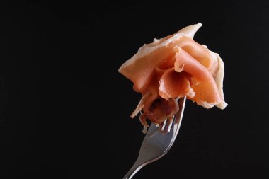 Prosciutto, jamon çatal karanlık bir arka plan üzerinde