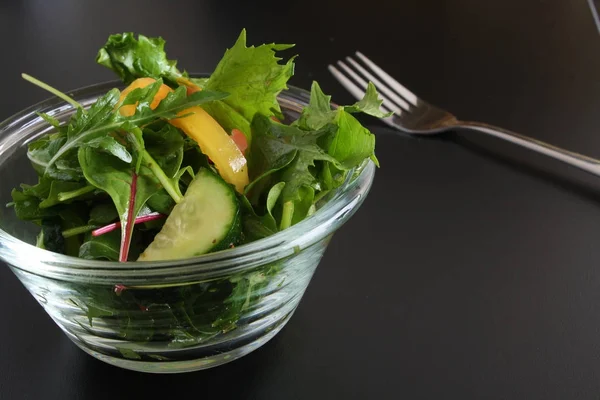 Salade de légumes sur fond noir — Photo