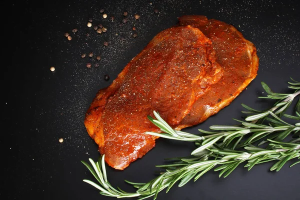 Escalope bistecca di maiale, rosmarino su fondo scuro — Foto Stock