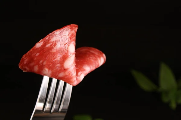 Salami Spanje worst Salchichon op een vork op een donkere, zwarte backgr — Stockfoto