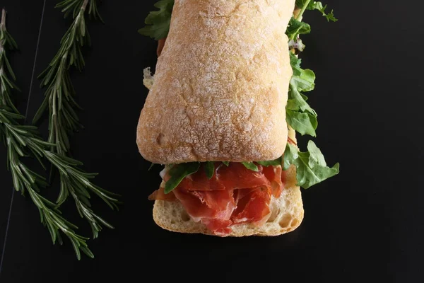 Sandwich prosciutto hamon ciabatta uno sfondo scuro — Foto Stock