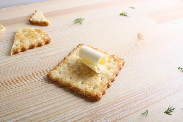 Cracker med smör på en trä bakgrund — Stockfoto