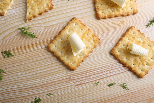 Cracker med smör på en trä bakgrund — Stockfoto