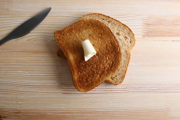 Toast med smör på en trä bakgrund — Stockfoto