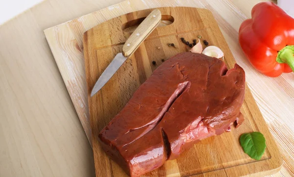 Beef liver on a wooden background